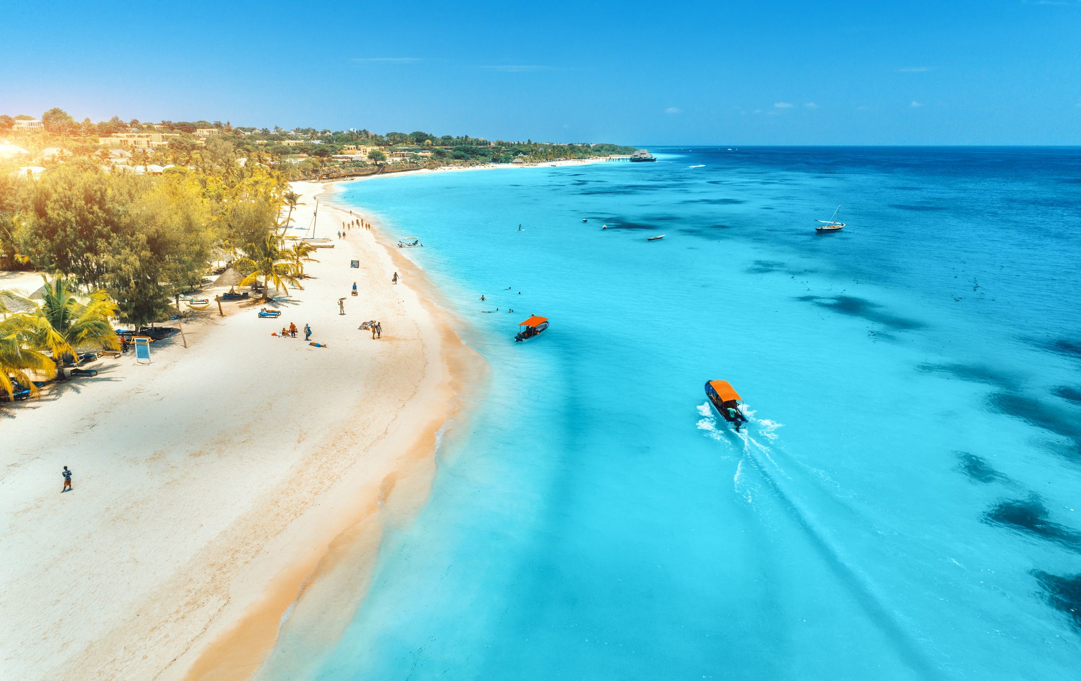 Aerial view of boats on a turquoise tropical coast